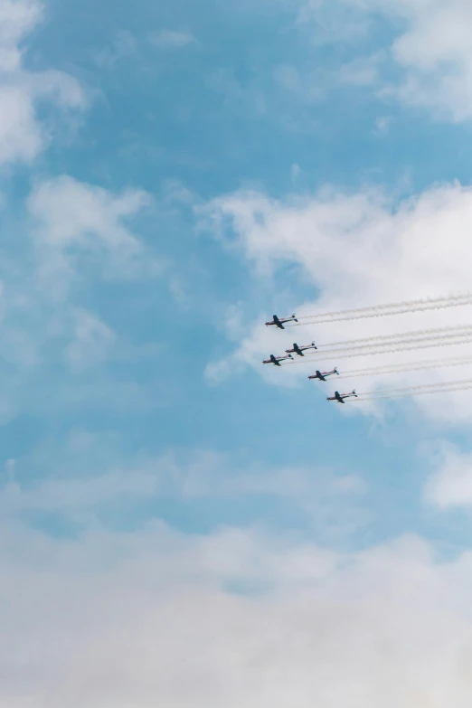 seven planes are flying in formation across the sky