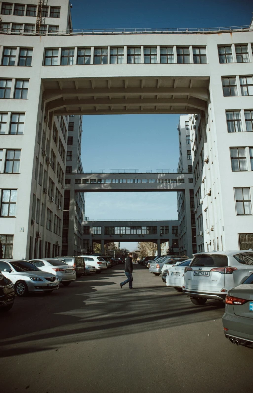 people are walking underneath a bridge in a parking lot