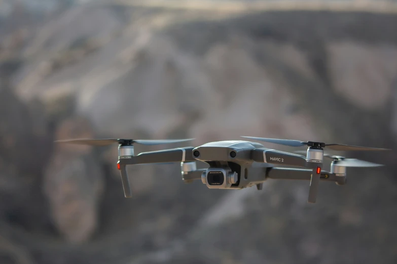 a small plane flying over a rocky mountain top