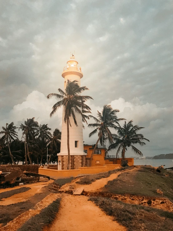 a large clock tower near a path leading to the ocean