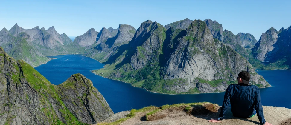 a person sitting on top of a mountain looking at the ocean