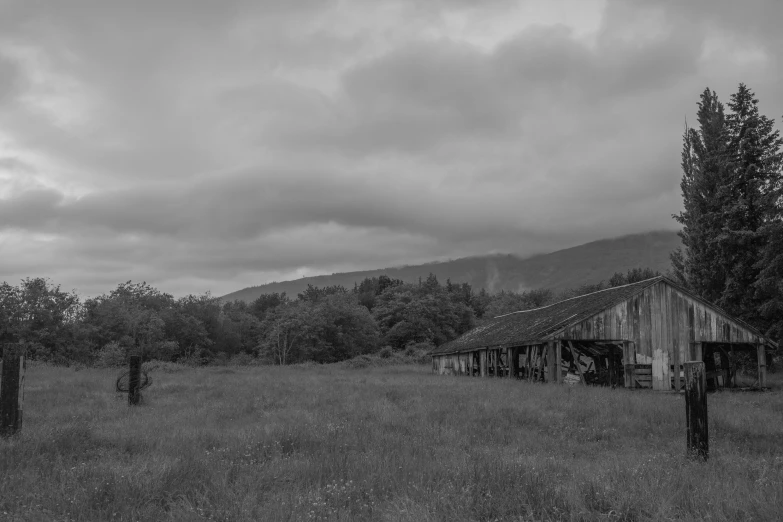 two men stand near a shack in a field