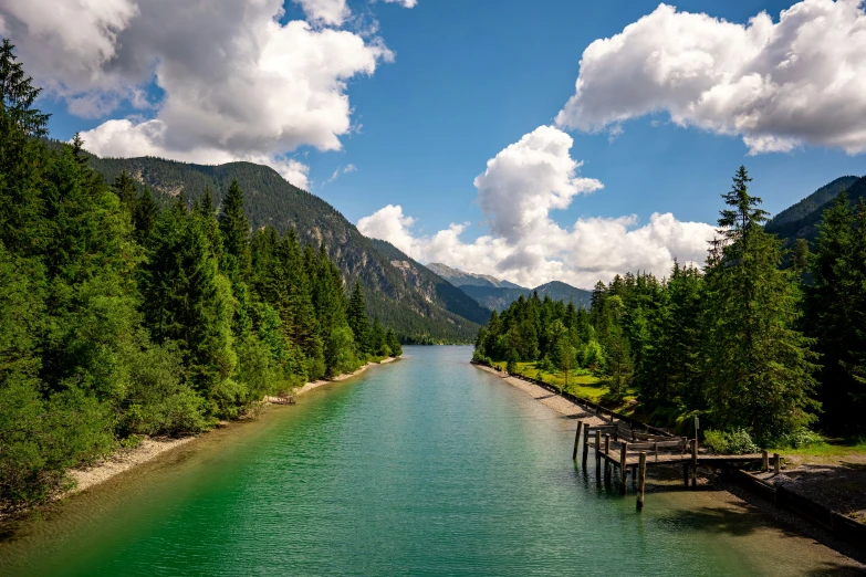 there is green water in the river and hills