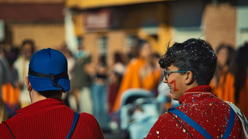 two people standing next to each other near a crowd