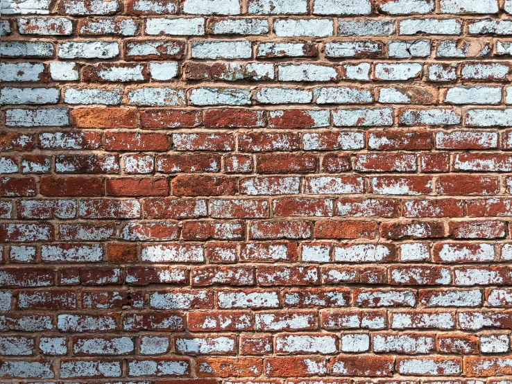 this brick wall has white and brown paint