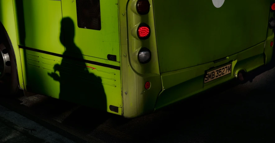 a green bus with a silhouette of the front person