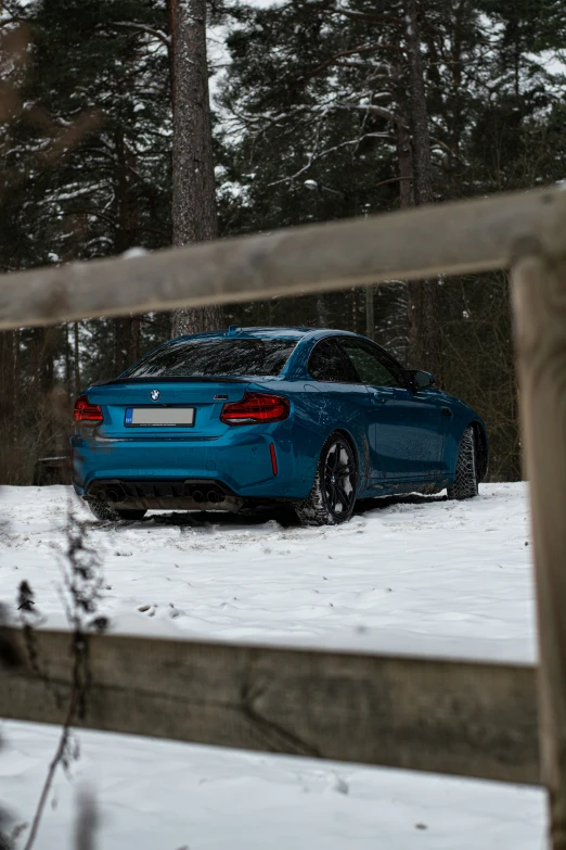 the blue car is parked in the snow