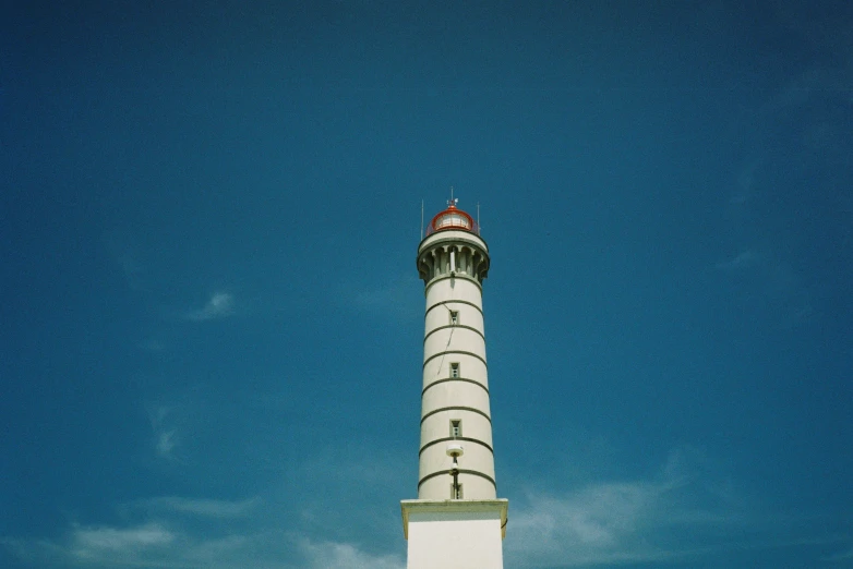 a white building with a red top and a sky in the background