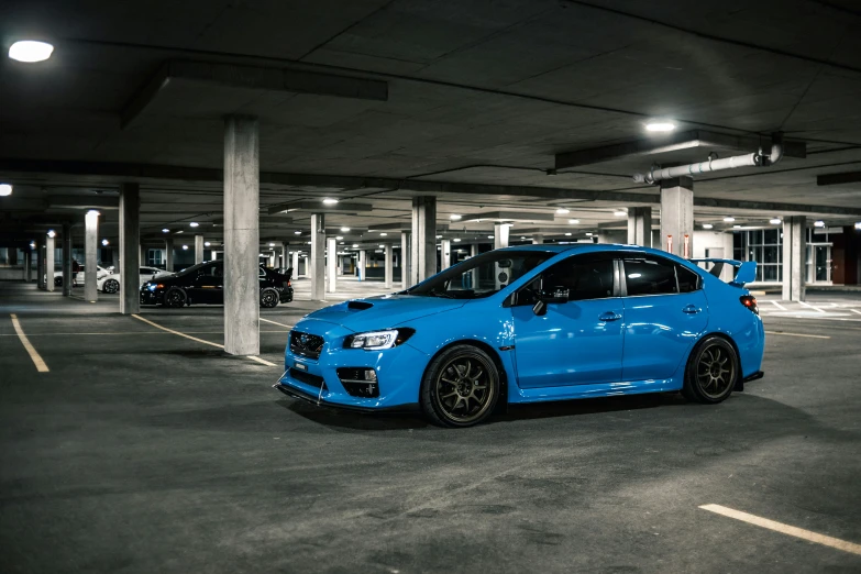 a blue car parked inside of a parking garage