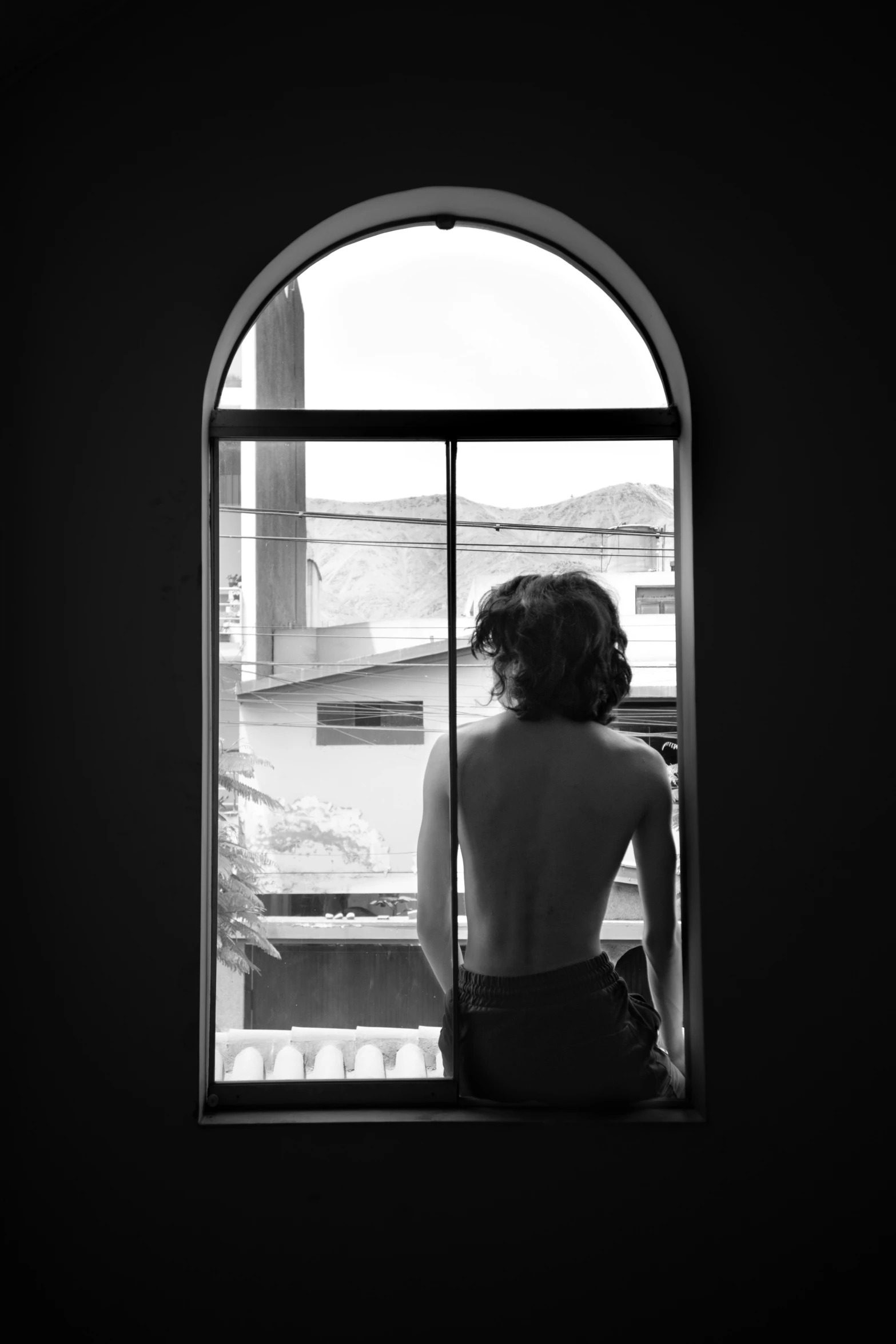 a woman sitting on top of a window sill