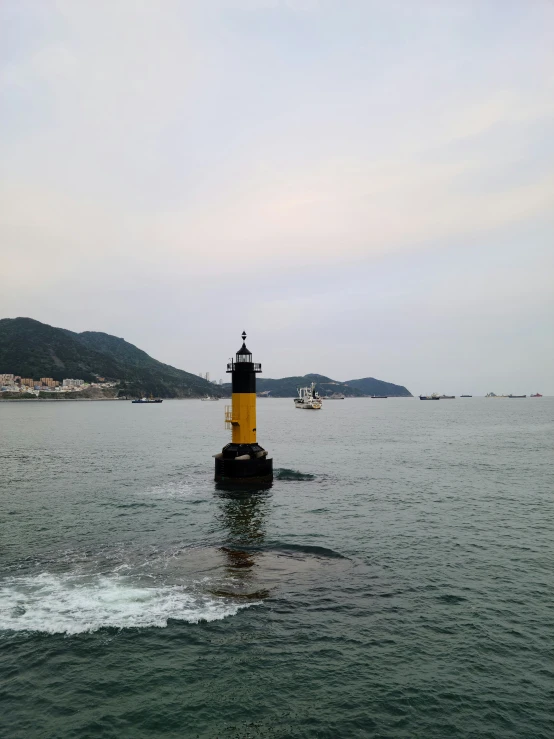 a boat is traveling along a body of water with a small lighthouse