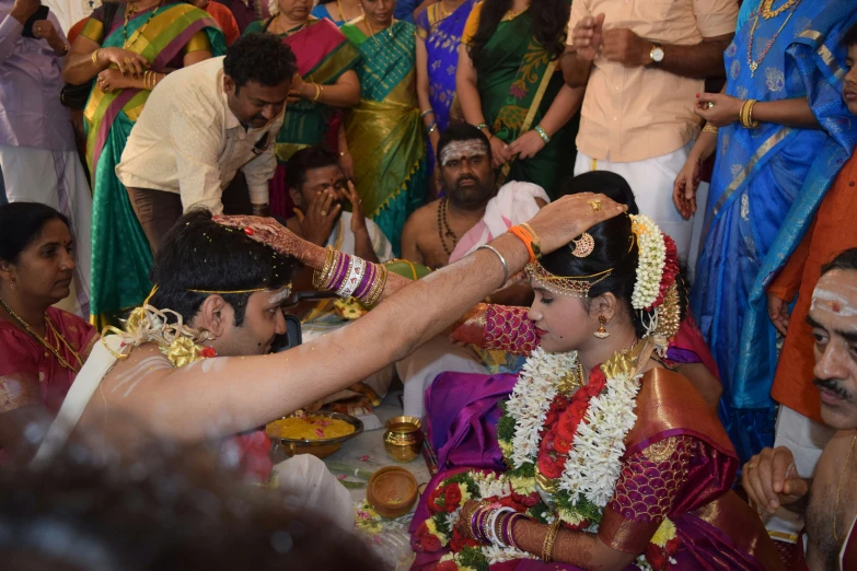 a couple in a traditional indian ceremony getting ready to throw rings