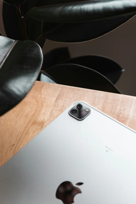 a silver apple ipad is shown sitting on a wooden table