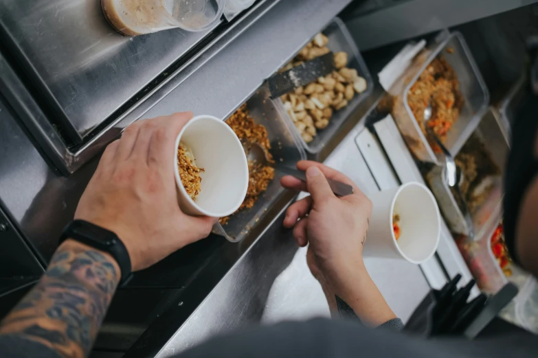 hands grabbing up some food from three bowls