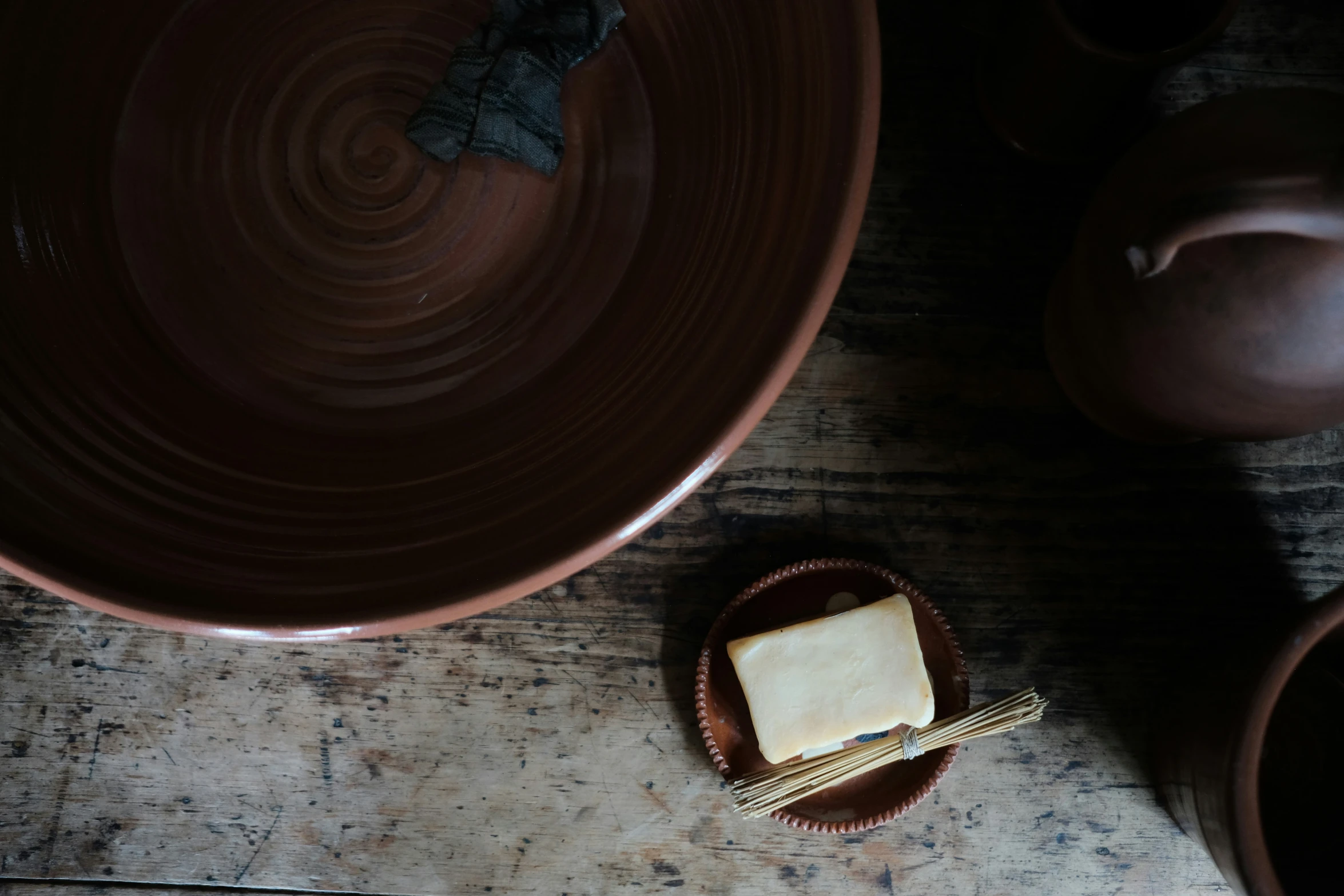 a clay bowl with some food sitting on a table