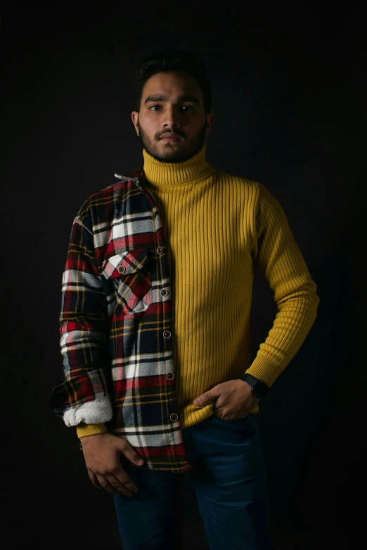 the young man is wearing a yellow sweater and jeans