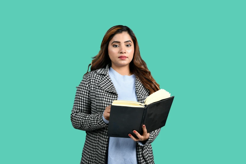 an indian woman reading a book while holding one