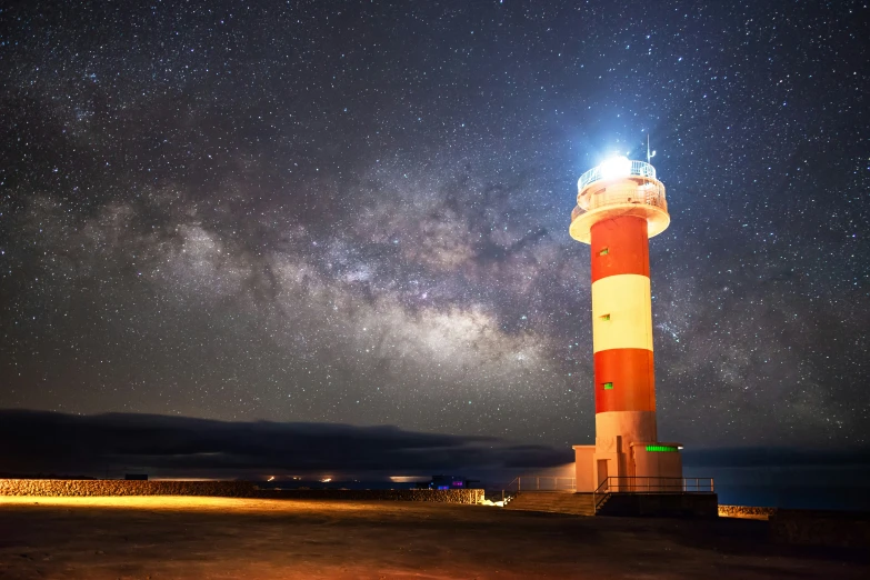 a light house in the middle of nowhere under some stars