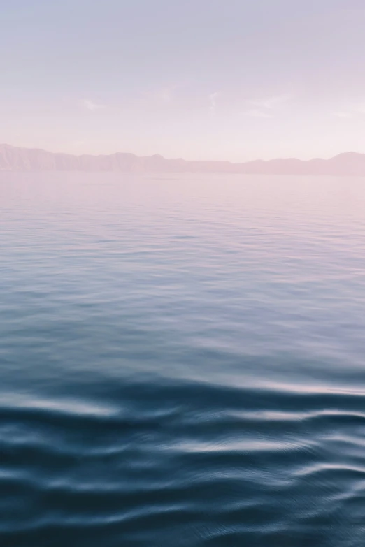 calm blue water with large mountains in the background