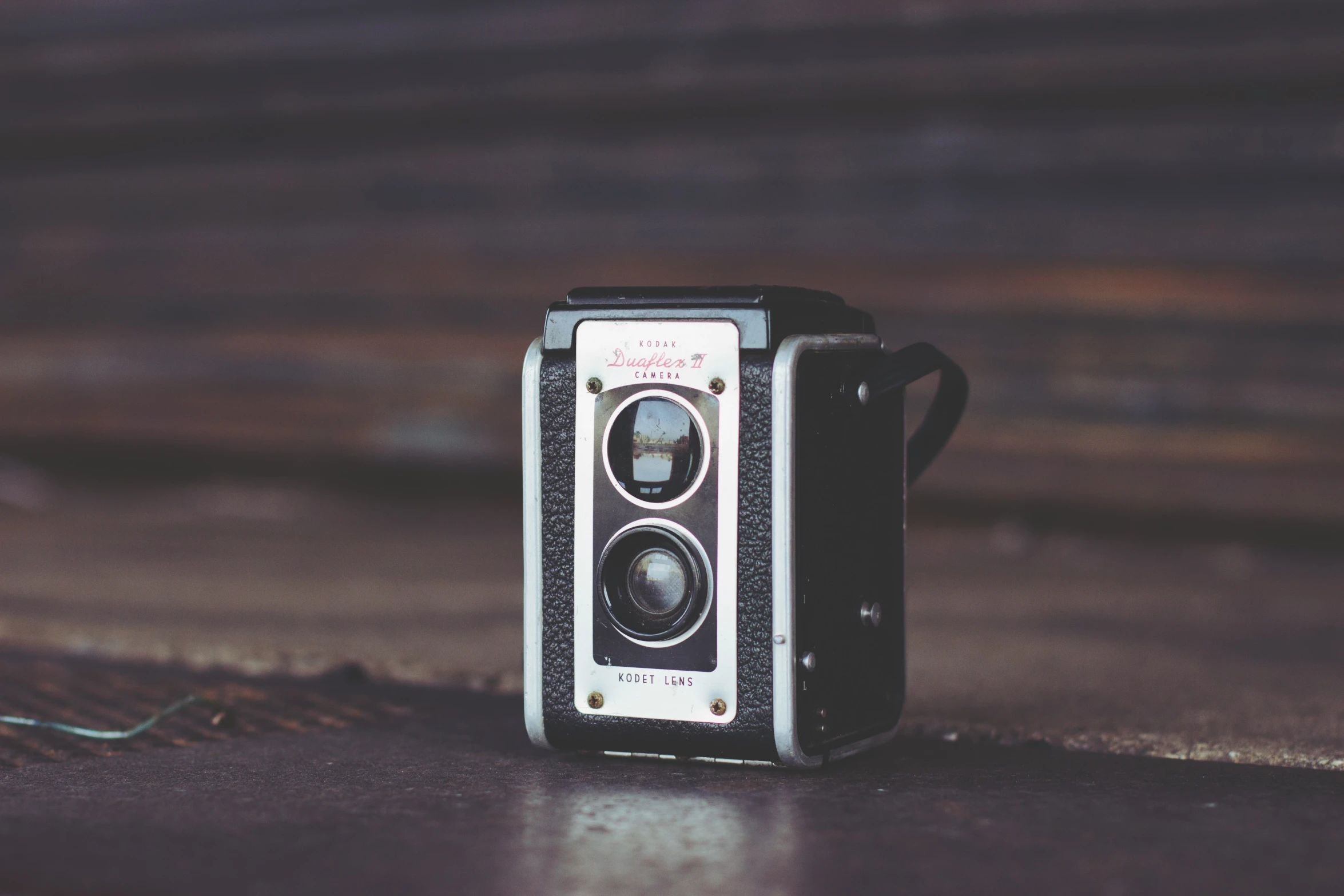 an old camera with a brown color sitting on the ground