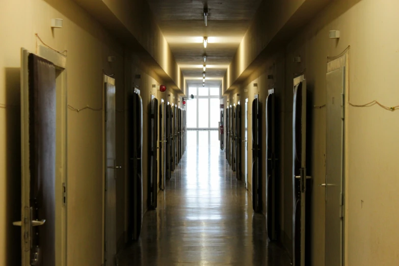 a narrow hallway is empty with doors on each side