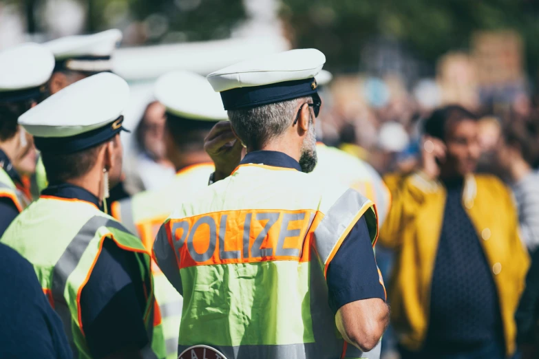 some policemen standing with each other and holding hats