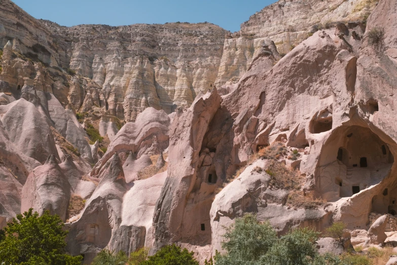 a cliff with carved windows and holes in it