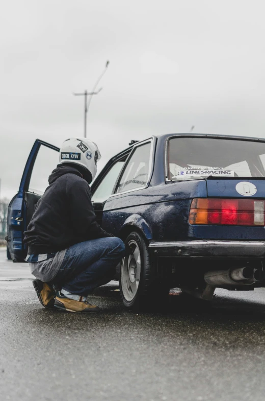 a man fixing the rear bumper of a car