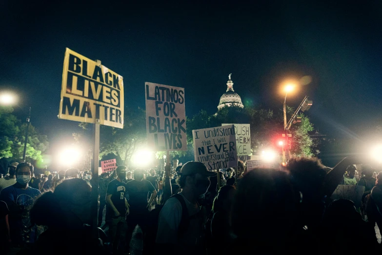 some people are holding lights and signs as they walk