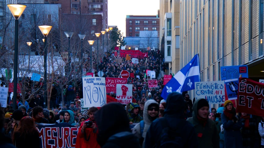 some people on a sidewalk with red and blue banners