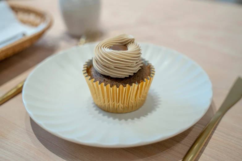 a single cupcake sitting on a plate with a fork