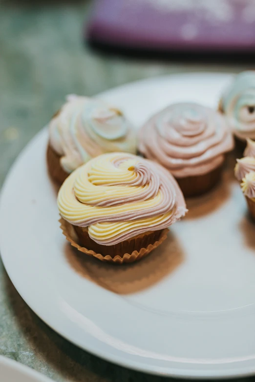 a plate has several cupcakes on it