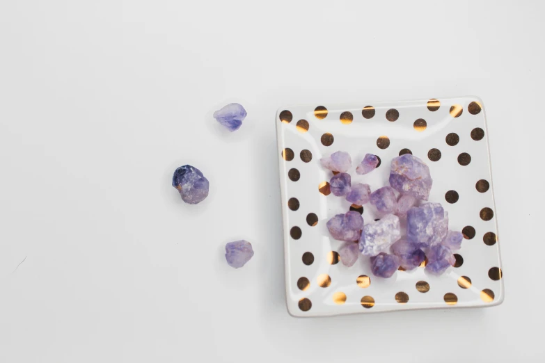 small square plate on white surface with purple crystals