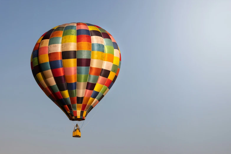 the rainbow colored  air balloon against the blue sky