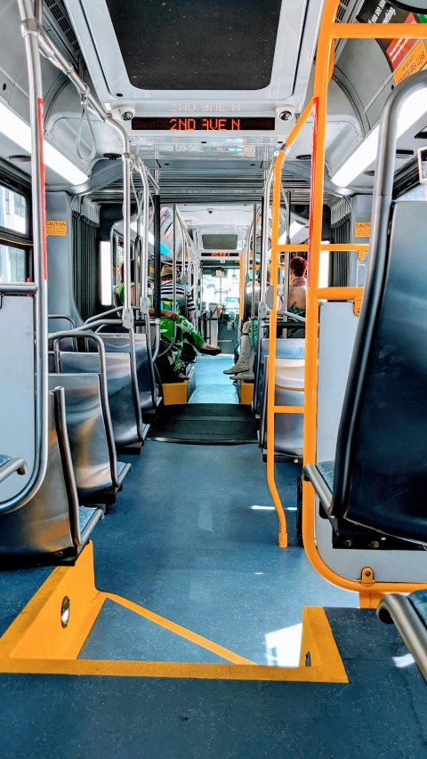 inside of an urban train looking towards the walkway and seats