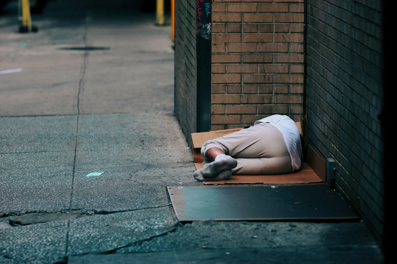 a man is lying on his side under a building