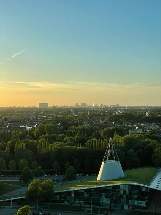 an aerial view of an industrial area and trees at sunset