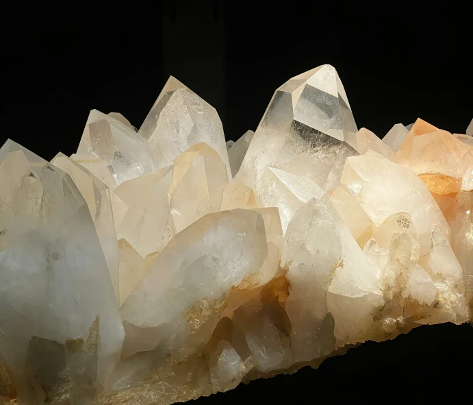 large piece of yellow quartz crystal rock is next to other large stones