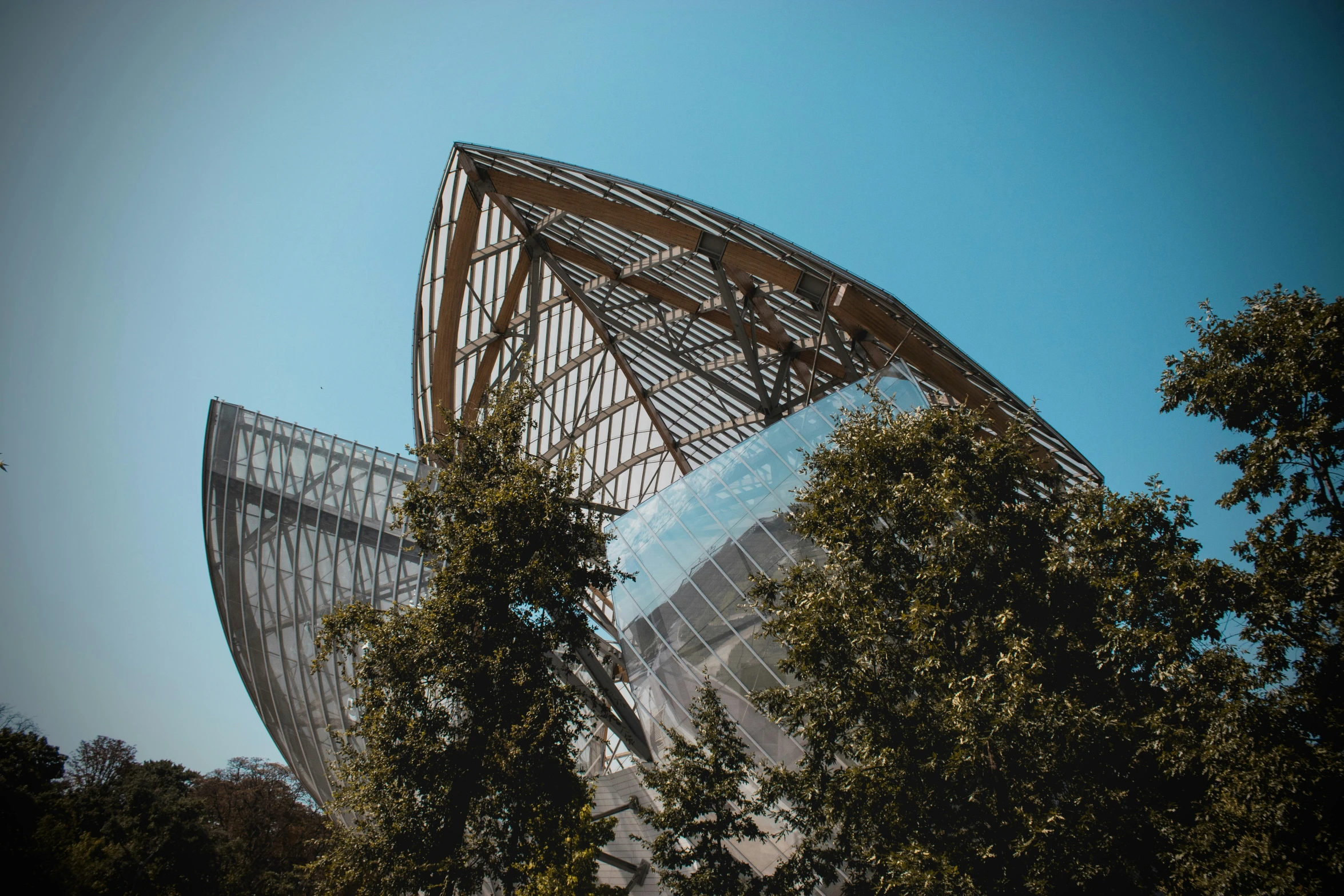 an artistic looking building in front of trees