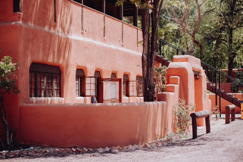 a red building sitting in the middle of a dirt road