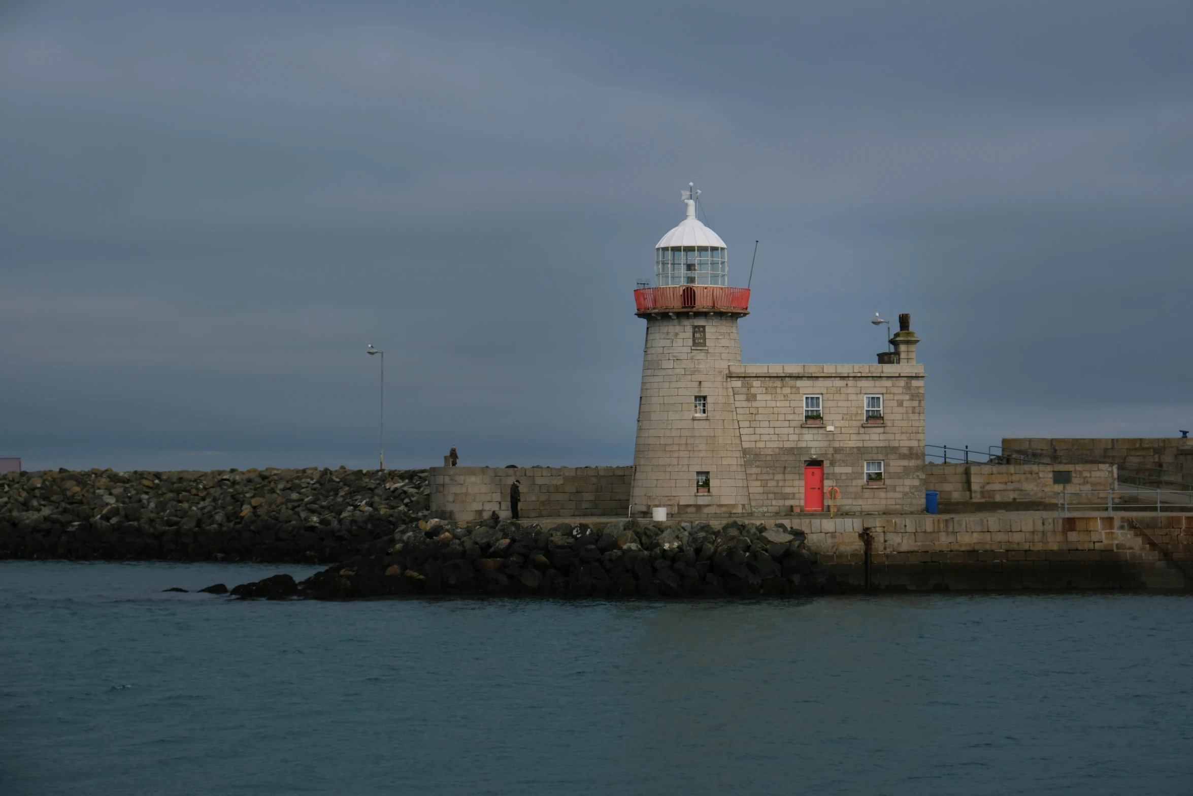 a lighthouse tower in an industrial area on a dark day