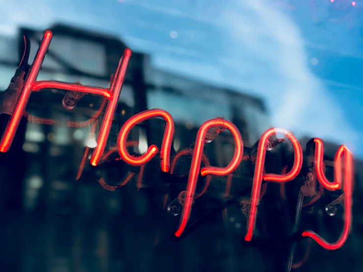 happy word made with neon lights as seen through window