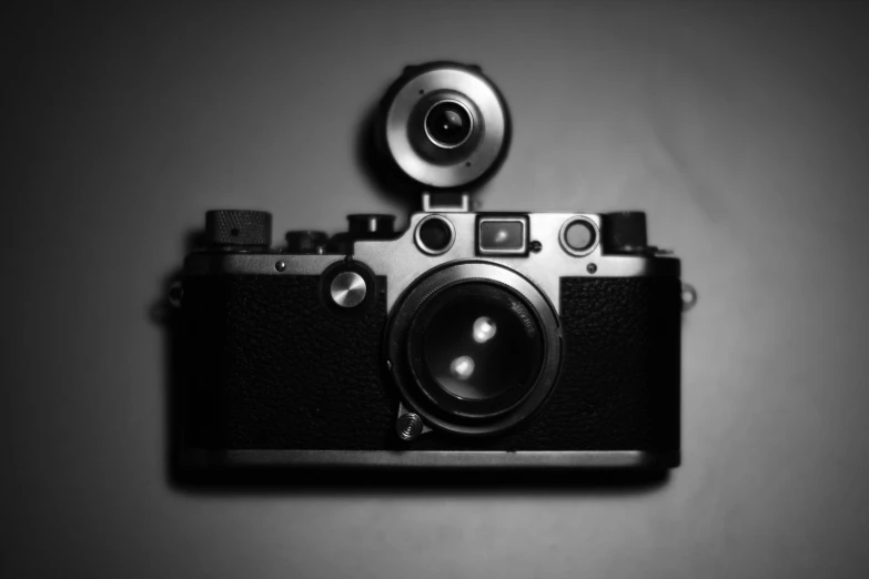 a silver and black camera sitting on top of a table