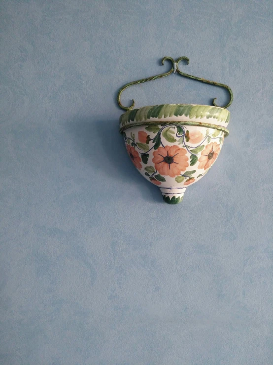 a ceramic hanging vase with a flowered design on it