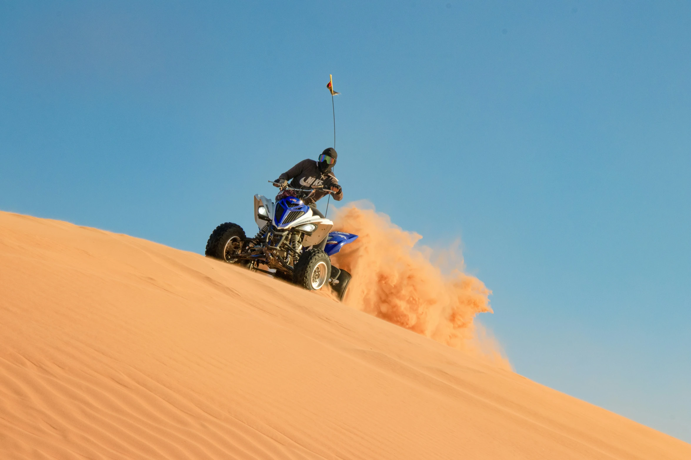 a person riding an atv on sand dune