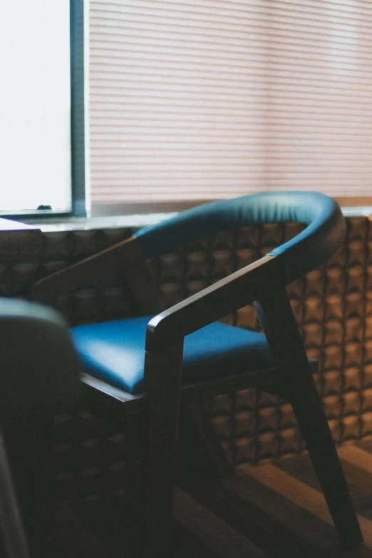 a chair next to a window with the blinds closed