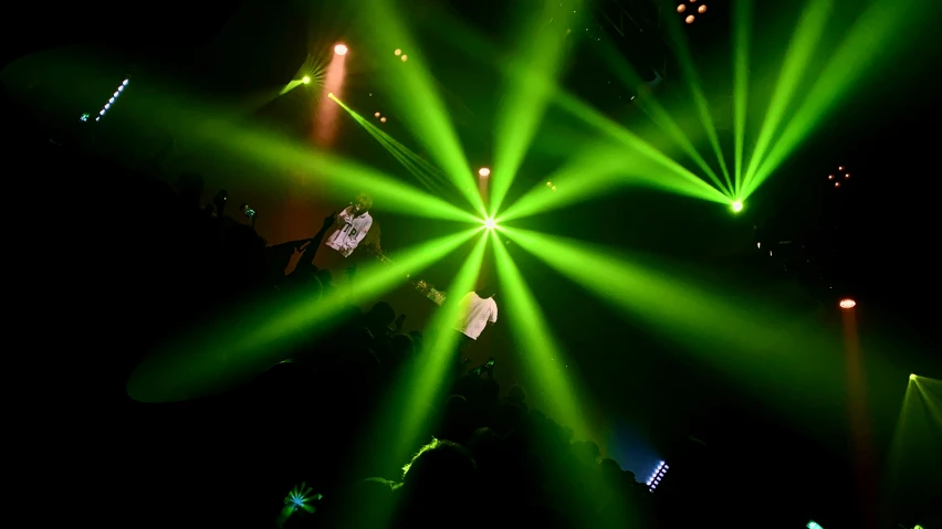 green rays from stage lighting create the shape of a star