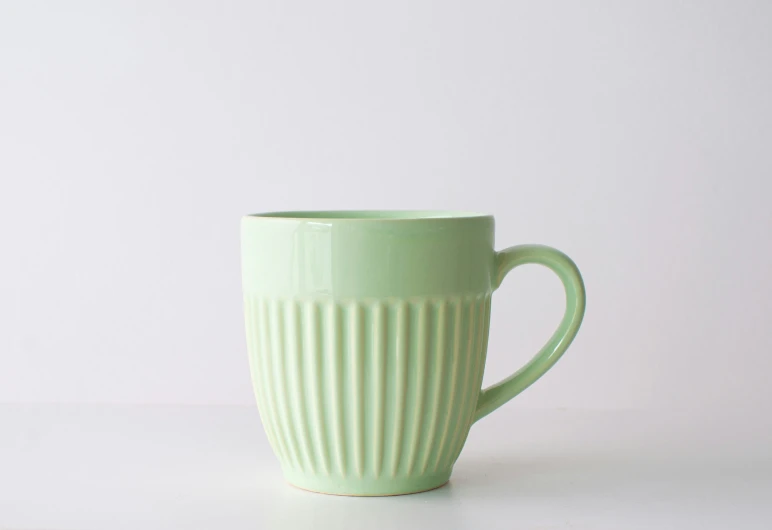 a green mug on a white table