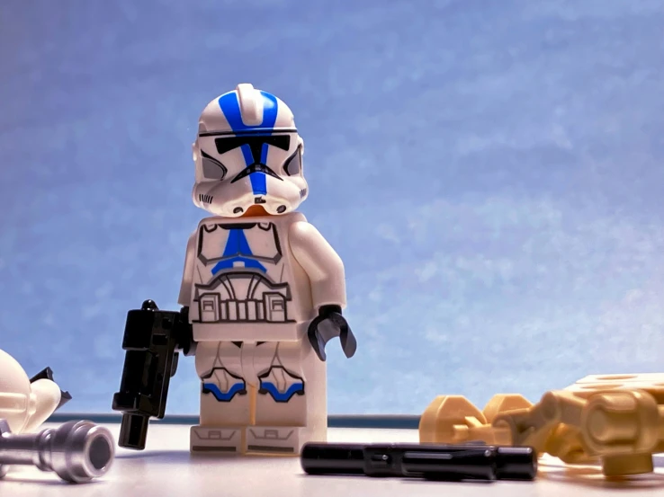 a lego storm trooper holding a gun next to smaller toy bears