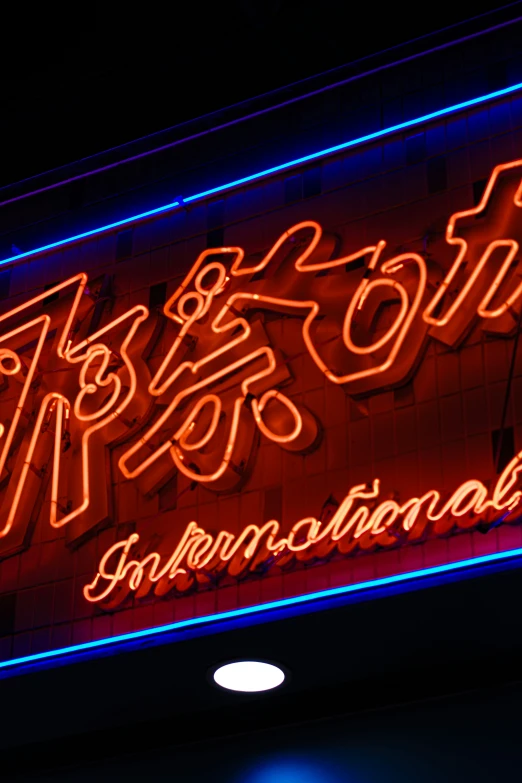 a brightly lit neon sign hanging from the side of a building